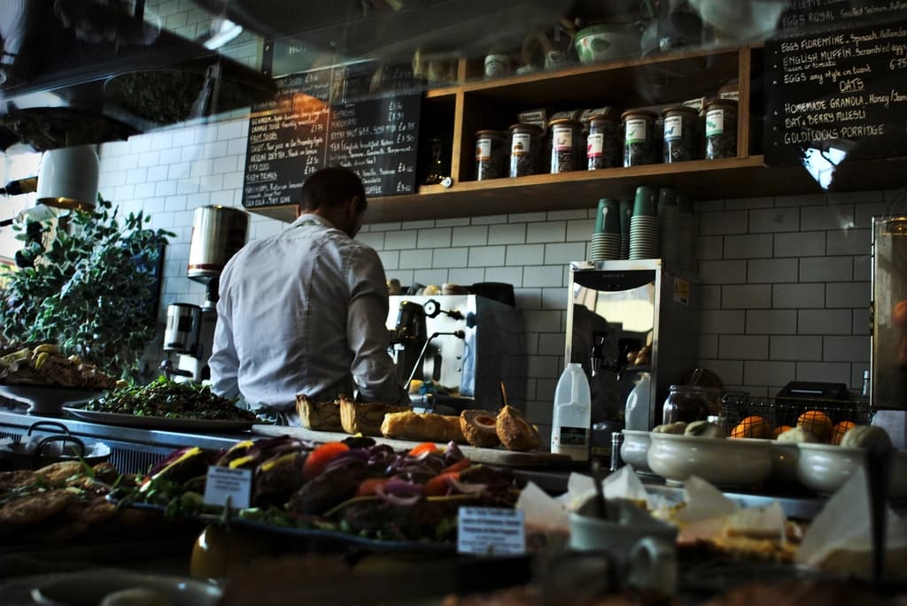 A café counter with a barista at work