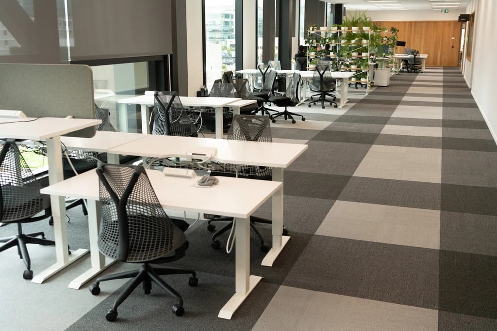 An open-plan office with rows of desks and chairs