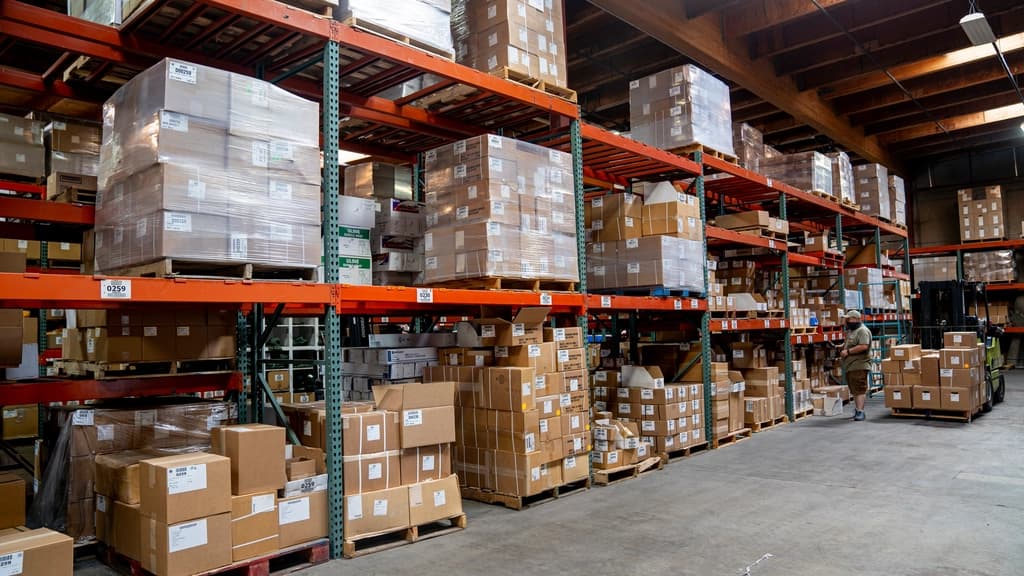Warehouse aisles with orange pallet racking stacked with boxes